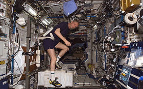 Thomas Reiter trainiert auf dem Fahrrad-Ergometer im Destiny Labormodul der ISS. Bild: NASA.