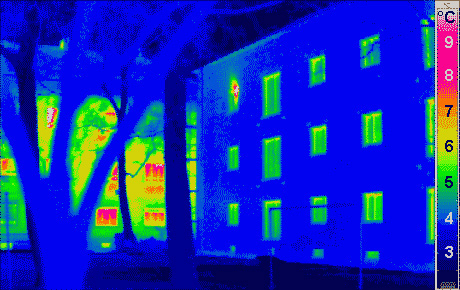 Wärmebild von Häusern. Links im Hintergrund ein normales Haus, das recht viel Wärme abgibt. Rechts ein gut isoliertes „Passivhaus“, das viel weniger Energie verbraucht. Bild: Passivhaus Institut
