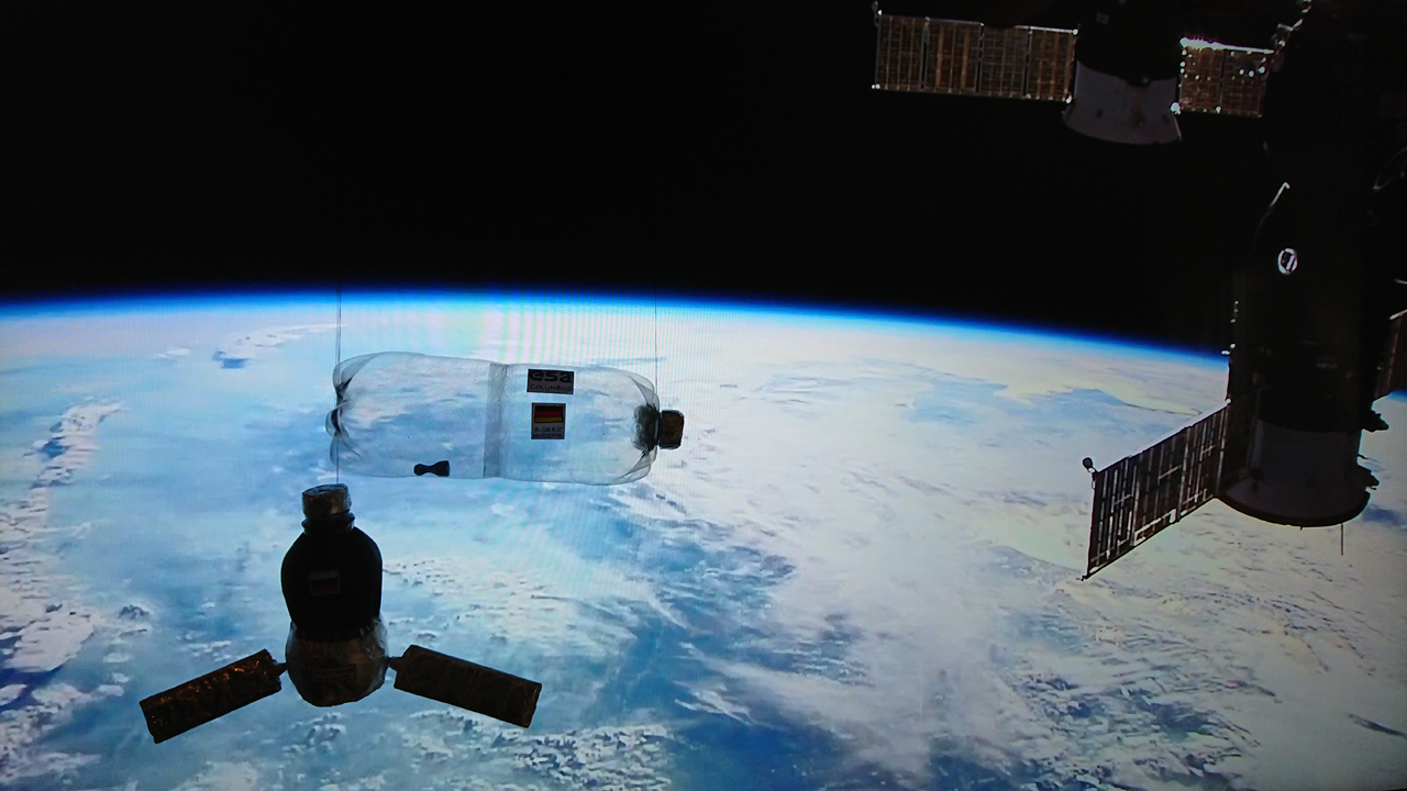 Die Flaschen-Raumstation Marke Eigenbau zeigt mit einfachsten Mitteln, warum Astronautinnen und Astronauten in der ISS schwerelos sind. Wirft man die durchsichtige „ISS“ in die Höhe, schwebt das Spielzeugfigürchen, das man hier unten in der Flasche liegend erkennt.  Modell und Foto: Nadine Maaß