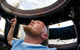 Alexander Gerst schaut aus der ISS auf die Erde, die hier „über“ ihm zu sein scheint. Aber er müsste sich nur „auf den Kopf“ stellen und schon wäre die Erde „unter“ ihm. Bild: NASA, ESA