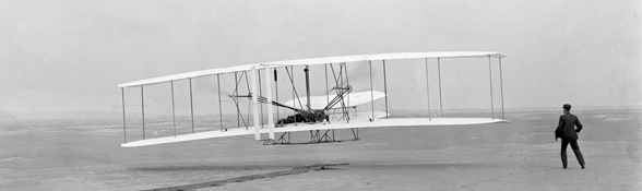 Die Gebrüder Wright bei einem Flugversuch. Sie gehörten zu den großen Luftfahrt-Pionieren. Bild: John T. Daniels, Library of Congress
