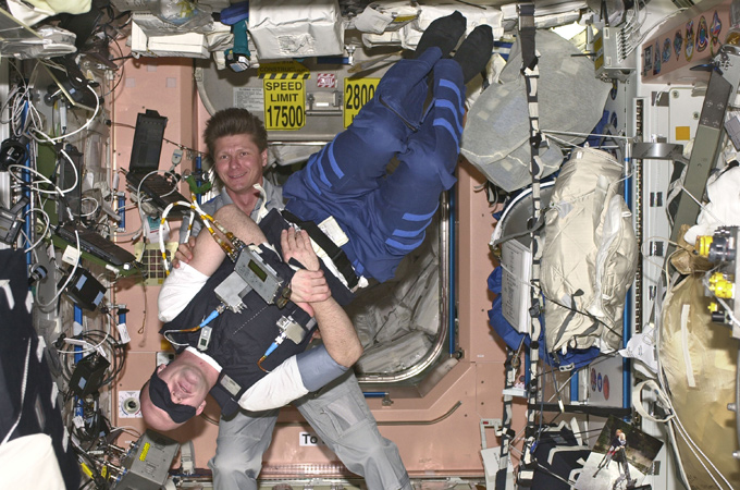 Gennady Padalka aus Russland (im Hintergrund) hilft ESA-Astronaut André Kuipers aus den Niederlanden bei einem medizinischen Versuch. Es geht dabei um den Gleichgewichtssinn. 
Bild: ESA