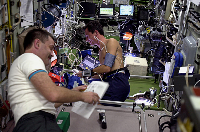 Alexander Kaleri aus Russland (links) und ESA-Astronaut Pedro Duque aus Spanien führen ein medizinisches Experiment durch. Wie man sieht, ist die ISS mit wissenschaftlichen Geräten geradezu vollgestopft: ein fliegendes High-Tech-Labor. 
Bild: ESA