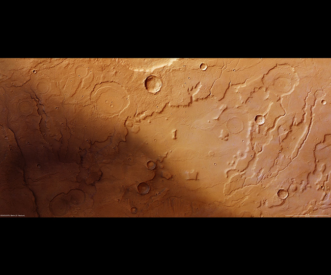 Dieses Bild der vom DLR entwickelten Kamera HRSC zeigt das Tiefland Acidalia Planitia auf der Nordhalbkugel des Mars. Man erkennt auch ausgetrocknete Flusstäler, die belegen: Hier muss früher einmal Wasser geflossen sein. In dieser Gegend beginnt die Geschichte von Mark Watney, der im Film von Matt Damon gespielt wird – mehr wird nicht verraten! Bild: ESA, DLR, FU Berlin