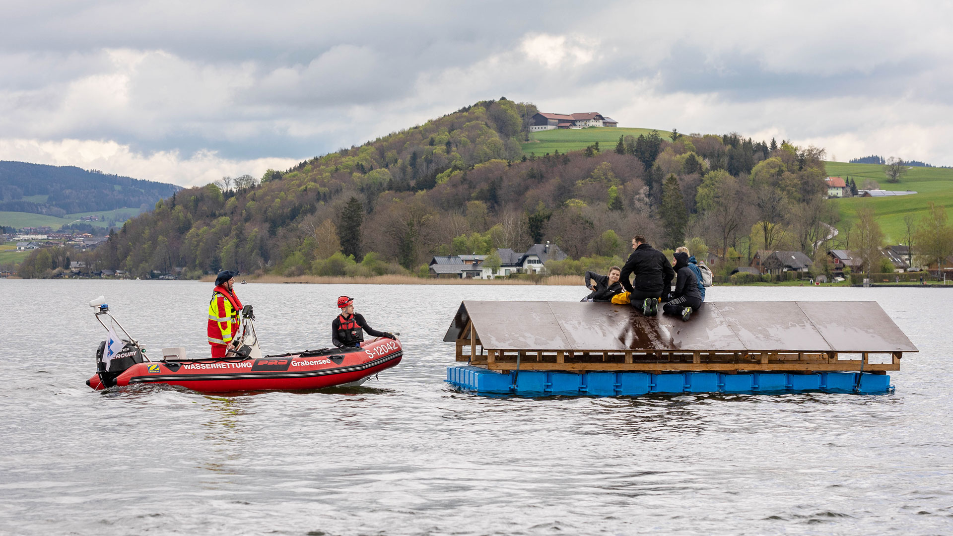 Personen wurden während der Übung mit Booten und Hubschraubern von schwimmenden Dächern im Wallersee geborgen.