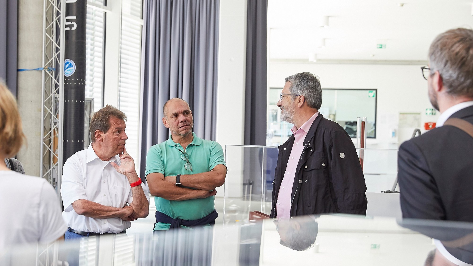 Das Bild zeigt Klaus Ranger MdL, Timo Natter, Bürgermeister der Gemeinde Langenbrettach im Gespräch mit Klaus Schäfer, stellvertretender Direktor des DLR-Instituts für Raumfahrtantriebe.