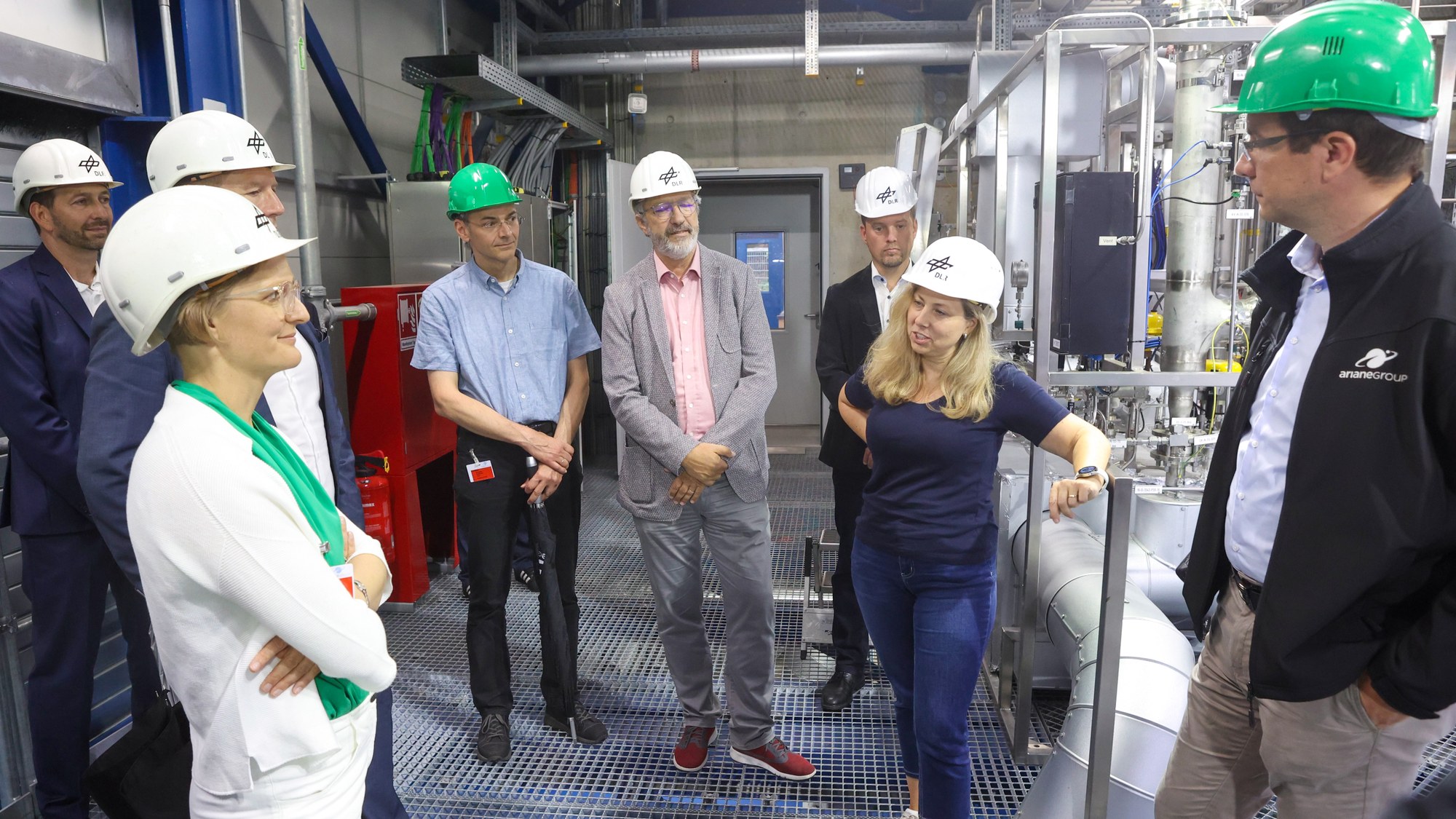 Beim Rundgang über den DLR-Standort besichtigte die Delegation den Prüfstand P5.2. Dort testet das DLR die neu konzipierte Oberstufe der künftigen Ariane-6-Trägerrakete. Entwickelt und gebaut hat sie das Unternehmen ArianeGroup. Von links: Parlamentarische Staatssekretärin Dr. Franziska Brantner, Patrick Kingsbury, ArianeGroup, Jens Schroeter, ArianeGroup, Holger Schmolzi, Mitglied im Kreisvorstand des Kreisverbands Bündnis90/Die Grünen Hohenlohe, Klaus Schäfer, stellvertretender Direktor des DLR-Instituts für Raumfahrtantriebe, Sascha Below, stellvertretender Leiter der DLR-Standorte Süd-West, Anja Frank, Leiterin der Versuchsanlagen im DLR-Institut für Raumfahrtantriebe, Sven Dietershagen, ArianeGroup.