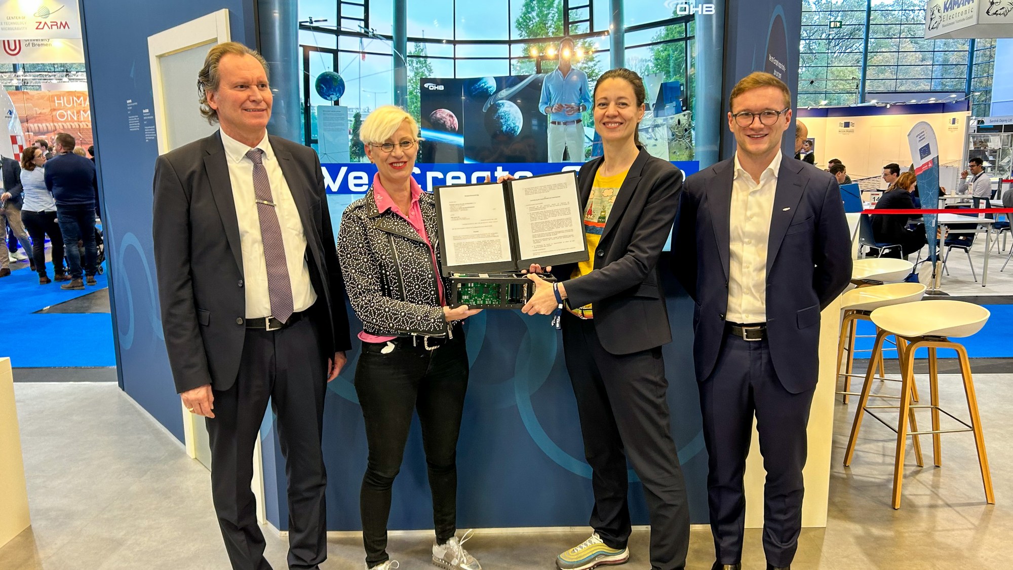 DLR und OHB besiegeln ihre Zusammenarbeit bei Avioniksystemen auf der Space Tech Expo, von links: Prof. Andreas Rittweger (Direktor am DLR-Institut für Raumfahrtsysteme), Prof. Dr.-Ing. Anke Kaysser-Pyzalla (Vorsitzende des DLR-Vorstands), Sabine von der Recke (Vorstandsmitglied bei OHB), Emile Jäger (Systems Engineering bei OHB)