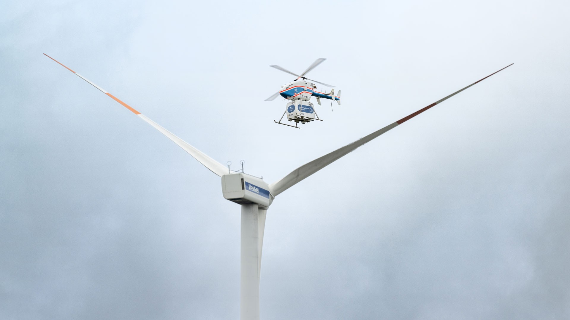 Der unbemannte DLR-Hubschrauber superARTIS nähert sich einer Windenergieanlage. Im Projekt „Upcoming Drones Windfarm“ geht es um die Frage, ob Drohnen für Offshore-Windparks Transportaufgaben übernehmen und Wartungspersonal entlasten können.