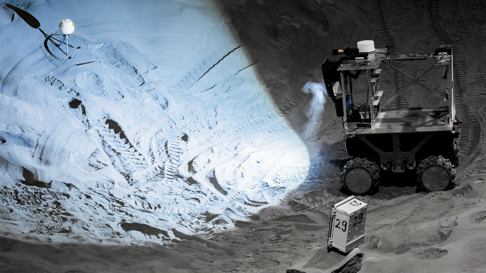 Der Rover befindet sich hier in einem Bereich der LUNA-Halle, der um drei Meter abgesenkt ist. Hier kann zum Beispiel die Exploration von Kratern getestet werden, oder das Abwerfen von Sensoreinheiten in schwierigen Umgebungen.