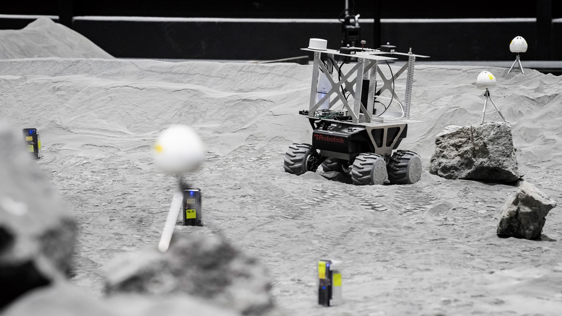 Die Rover bewegen sich in der LUNA-Halle auf Regolith-Simulat, das dem Regolith auf dem Mond täuschend ähnlich ist. Die Steine sind der Mond-Geologie nachempfunden.