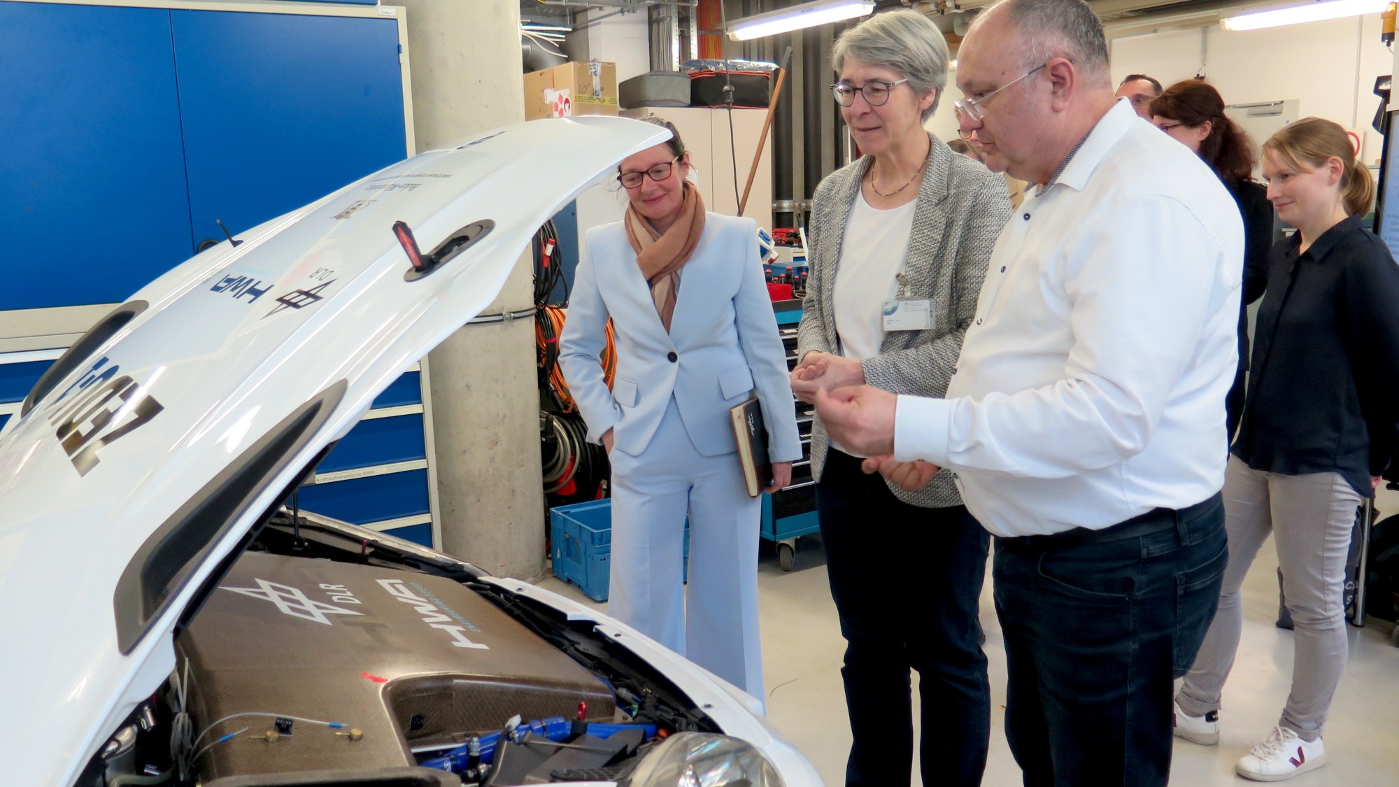 DLR-Mitarbeitende zeigen Elke Zimmer MdL die Filtereinheit des DLR-Forschungsfahrzeugs ZEDU-1.