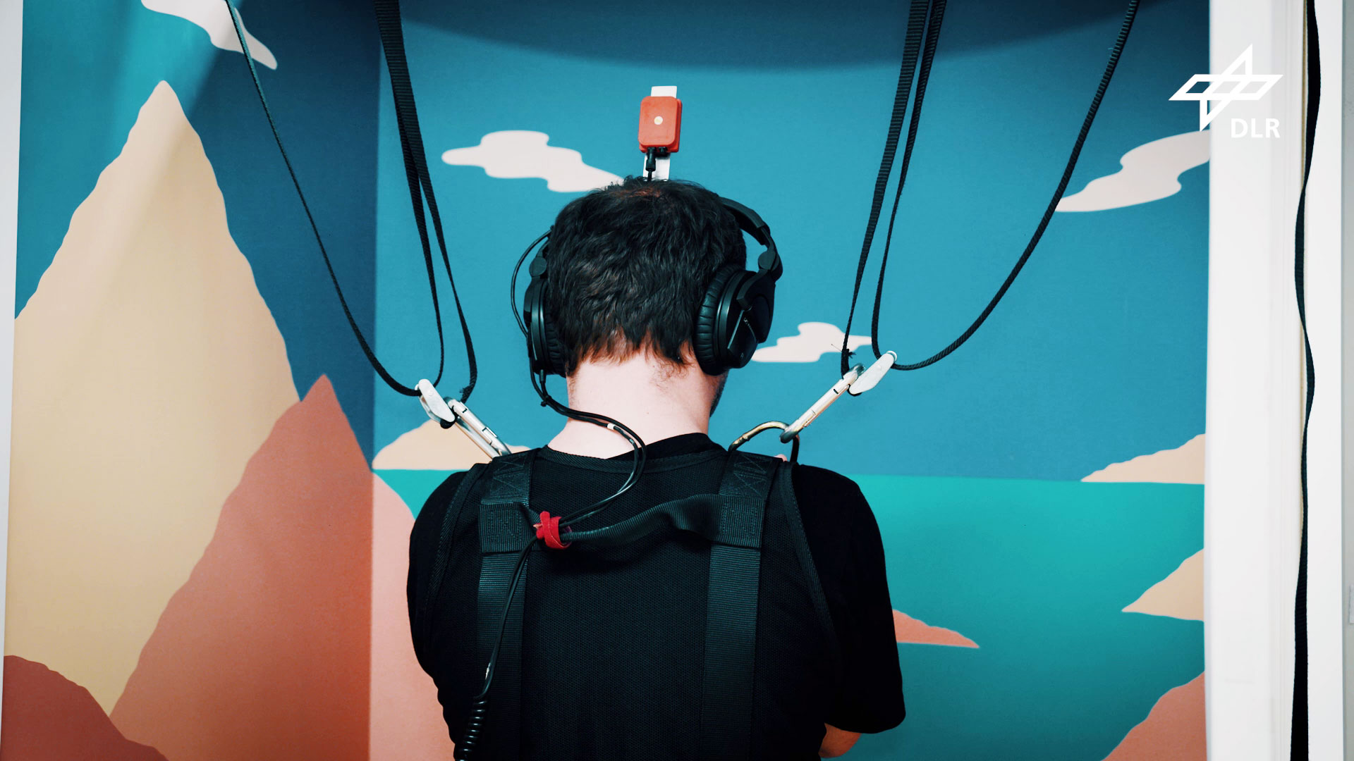 Ein Proband gleicht Bewegungen mit Blick auf einen künstlichen Horizont aus. Er ist dabei durch Gurte gesichert.