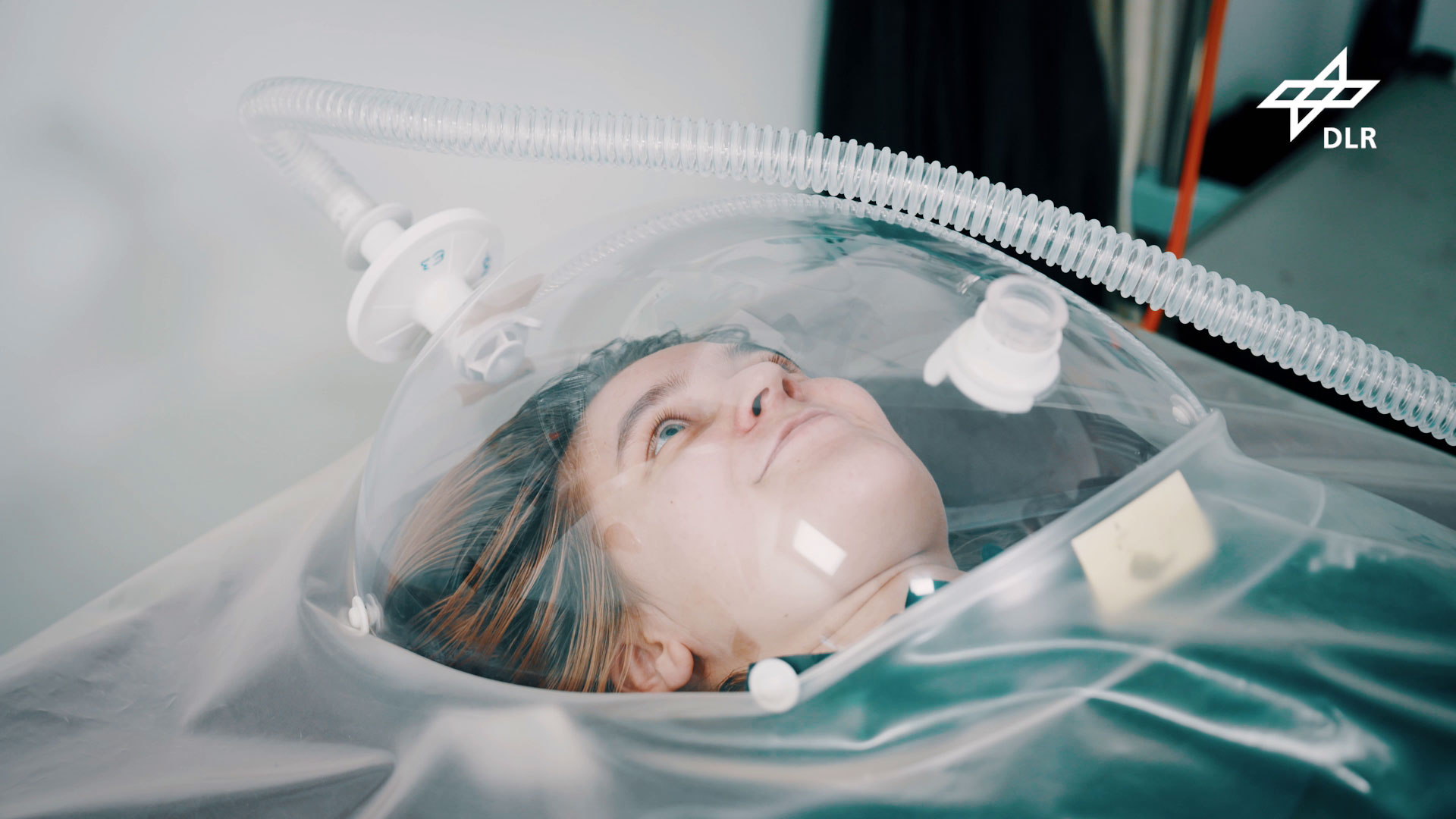 Eine Teilnehmerin liegt unter einer Haube. So werden Veränderungen des Stoffwechsels über die Atemluft gemessen.