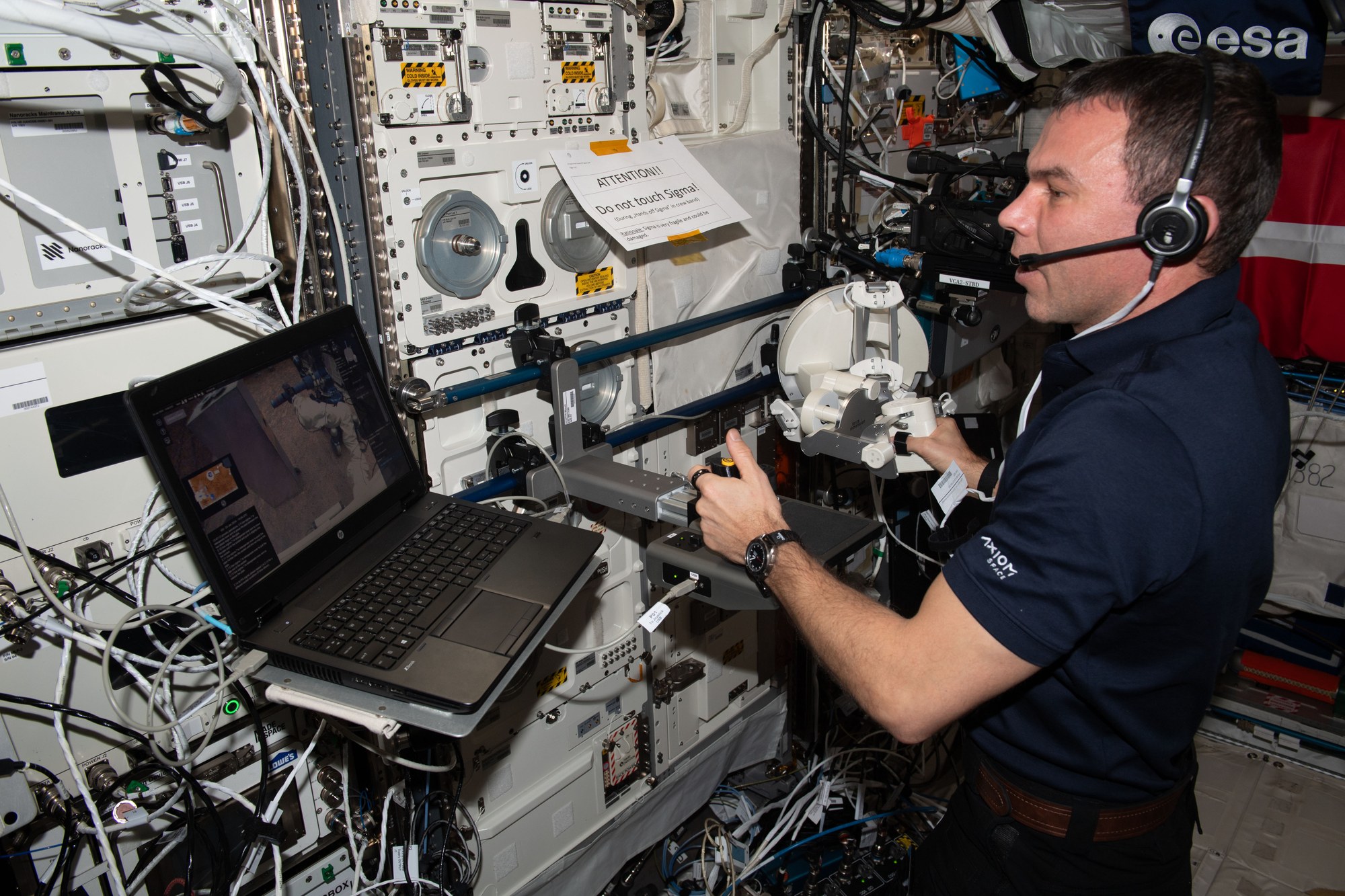 ESA-Astronaut Marcus Wandt steuert von der ISS aus, zu sehen auf einem Bildschirm, einen Roboterarm.