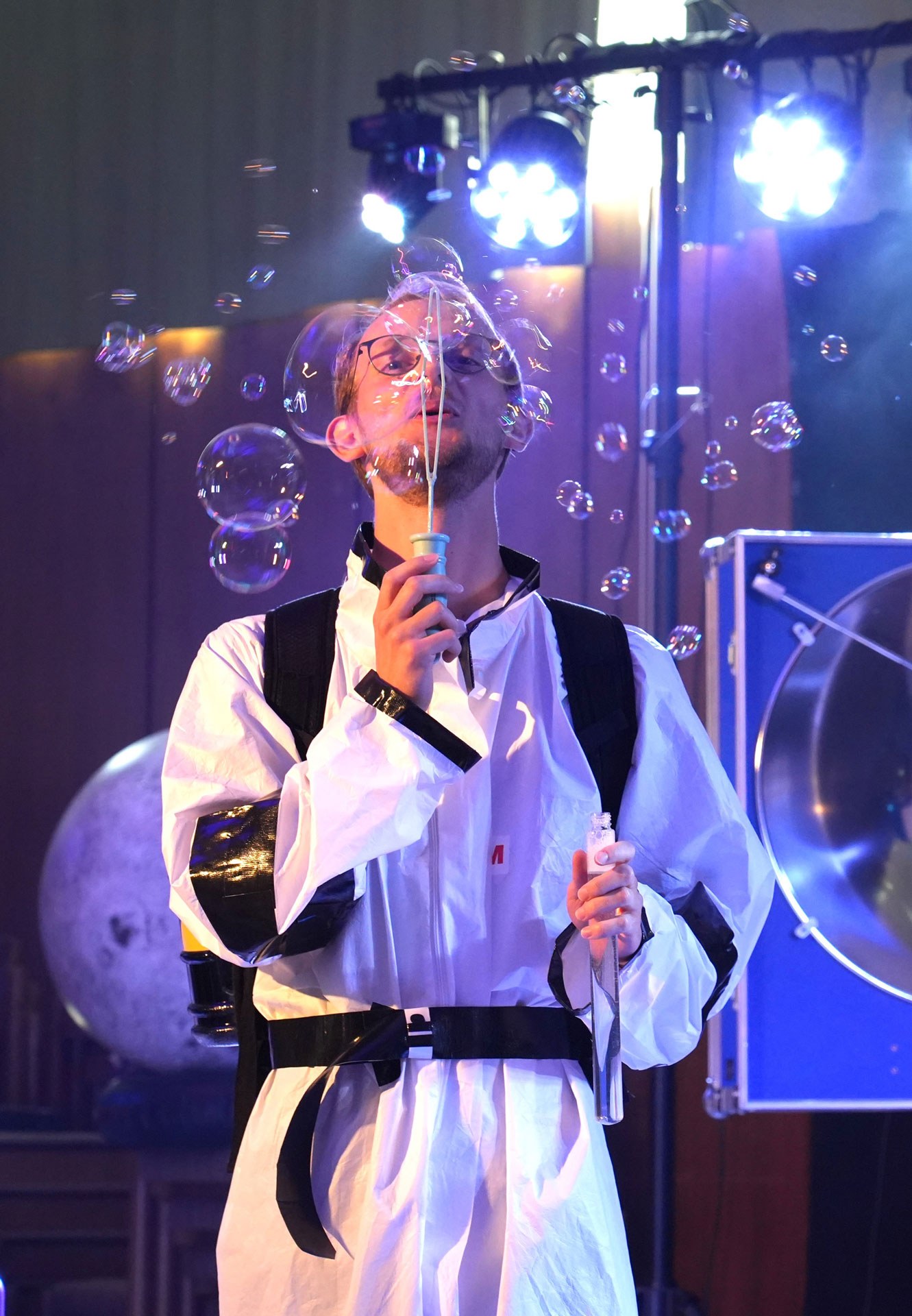 Moderator beim Seifenblasenexperiment auf der Bühne