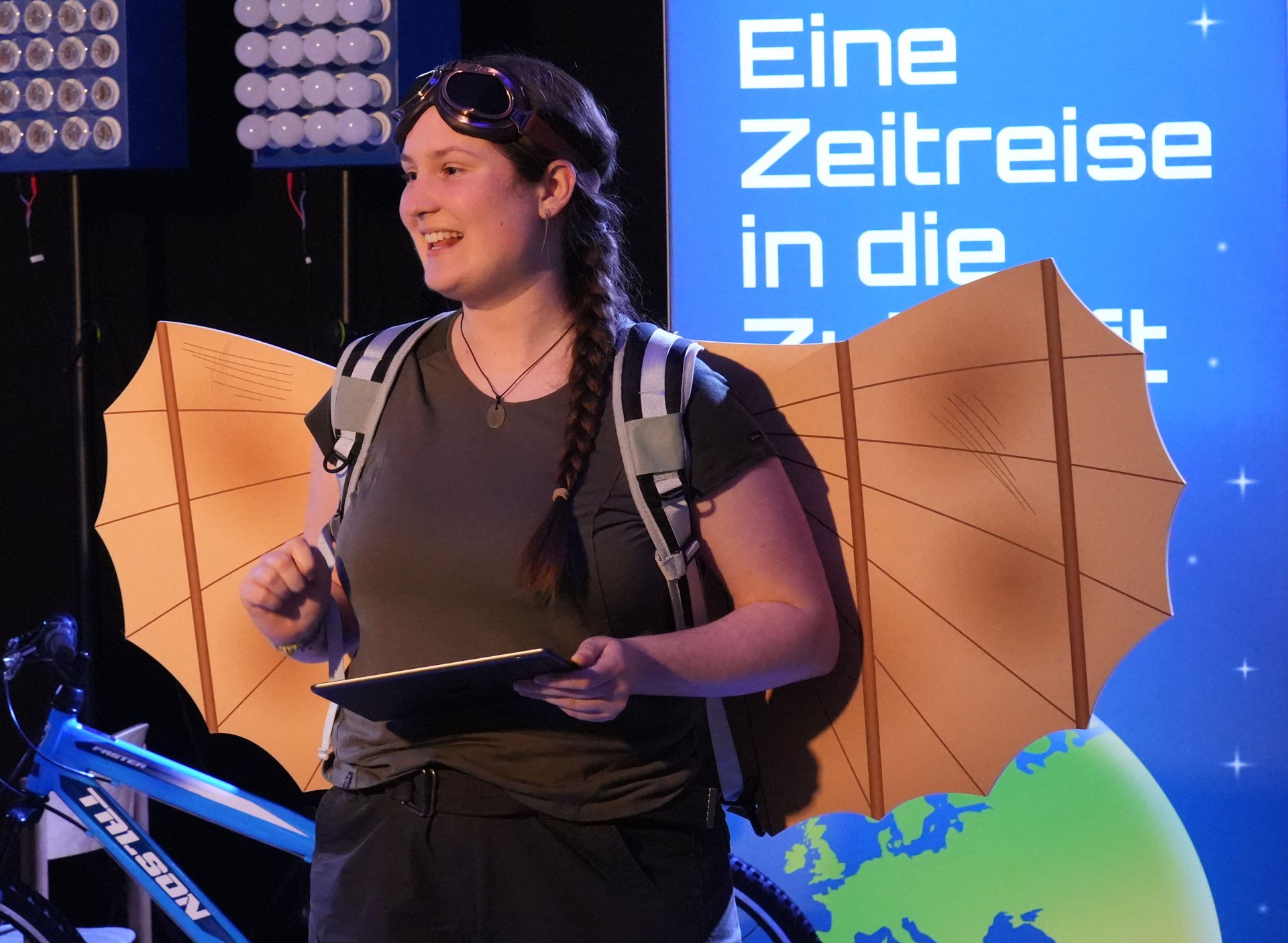 Moderatorin bei der DLR_Raumfahrt_Show mit einer Mini-Ausgabe des Gleiters von Otto Lilienthal