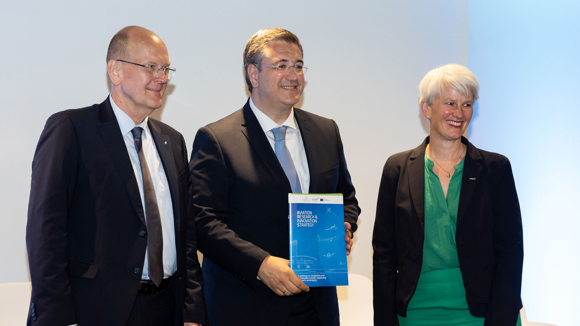 Gruppenbild: Arndt Schoenemann, CEO der DFS Deutsche Flugsicherung GmbH (links), und Sabine Klauke, CTO bei Airbus (rechts), überreichen die Strategie ARIS an den EU-Kommissar für nachhaltigen Verkehr und Tourismus Apostolos Tzitzikostas (Mitte).