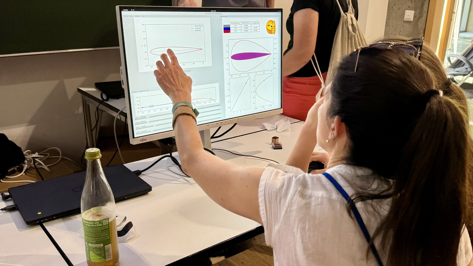 Ein Mädchen vollzieht an einem Computer die Simulation von Tragflächenprofilen nach.