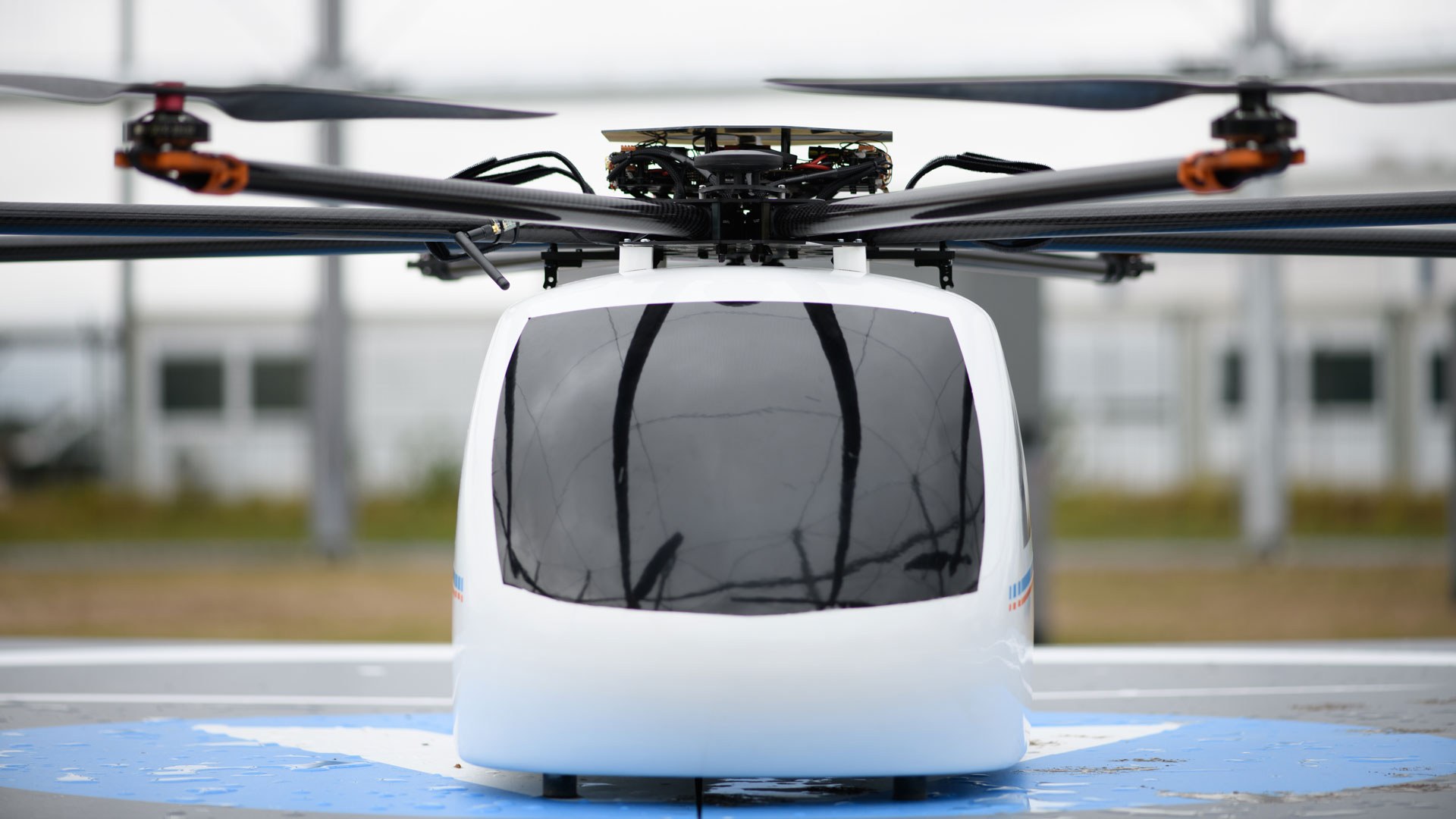 Das Bild zeigt den Prototypen einer Drohne im Drohnenkäfig auf einer Landeplattform.