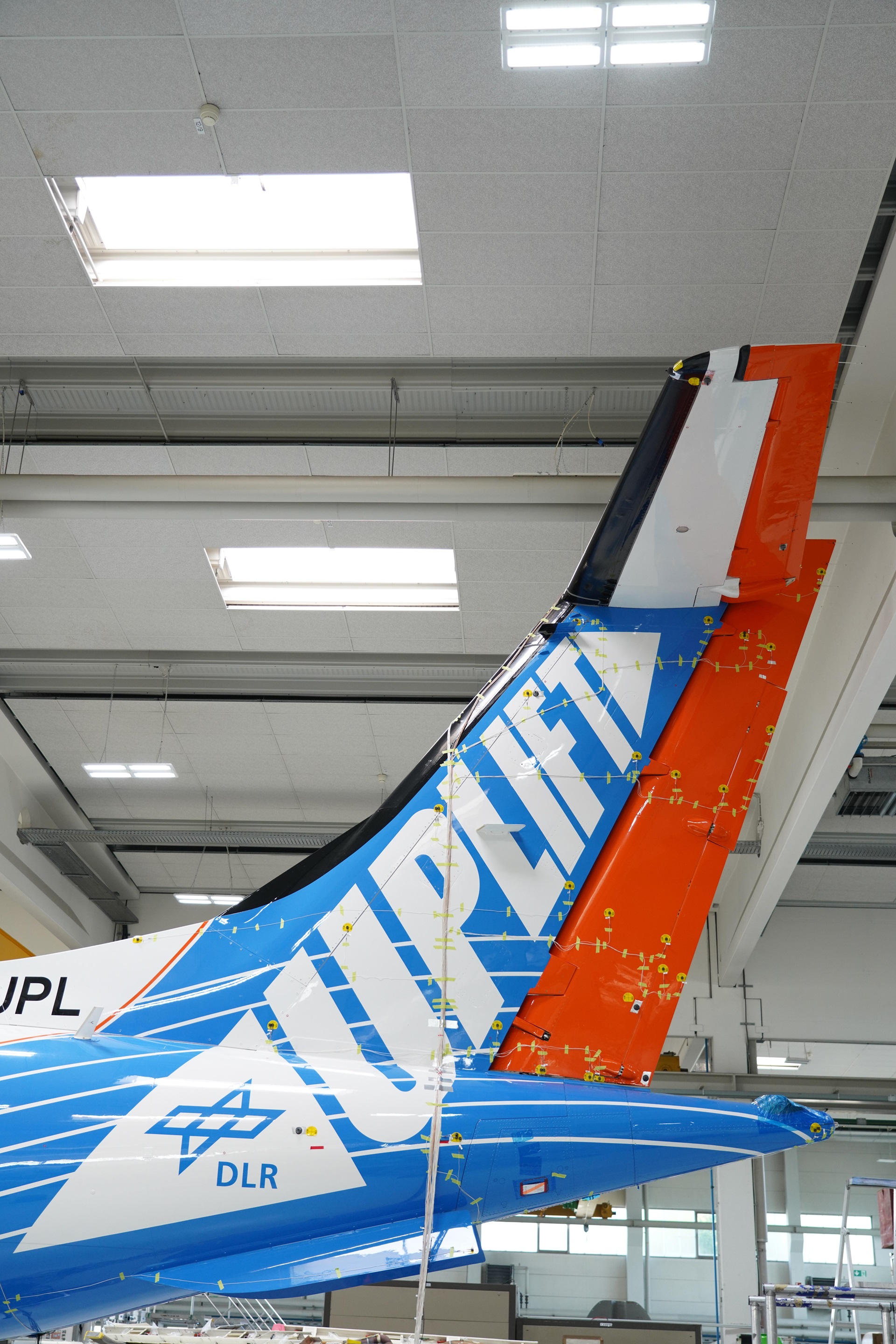 buntes Bild, Blick auf den verkabelten Leitwerk  des DLR-Forschungsflugzeugs D328® UpLift, Standschwingungstest