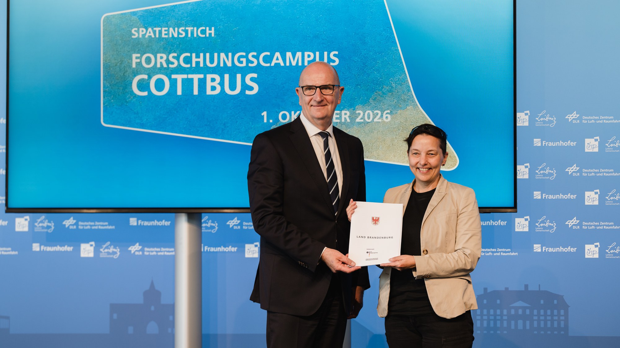 Brandenburgs Ministerpräsident Dietmar Woidke übergibt den Förderbescheid zur Erschließung des Forschungscampus Cottbus an das DLR. Dr. Anke Pagels-Kerp, Bereichsvorständin Raumfahrt, nahm den Förderbescheid entgegen.