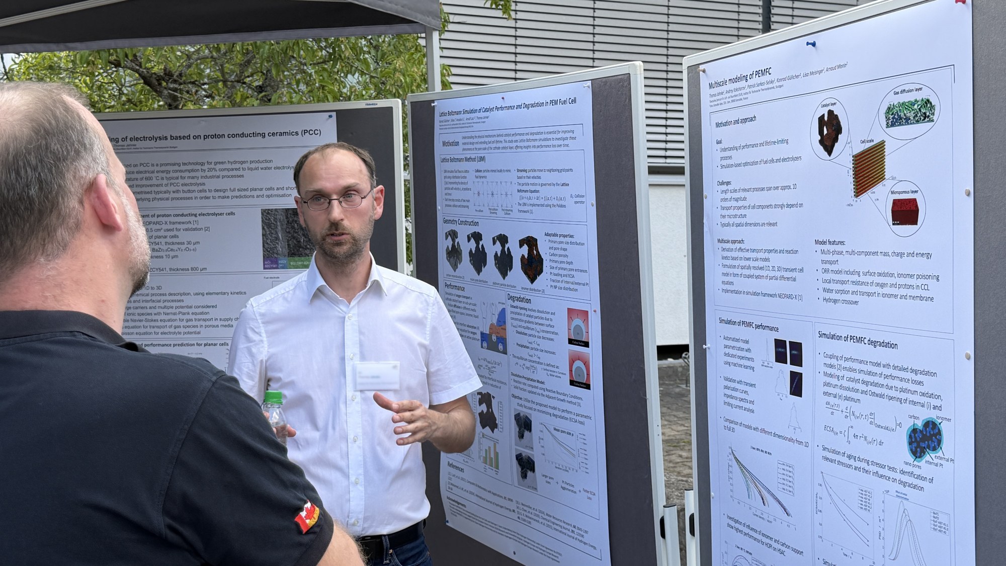 Gespräch mit Besuchern an Plakaten über Modellierung elektrochemischer Vorgänge