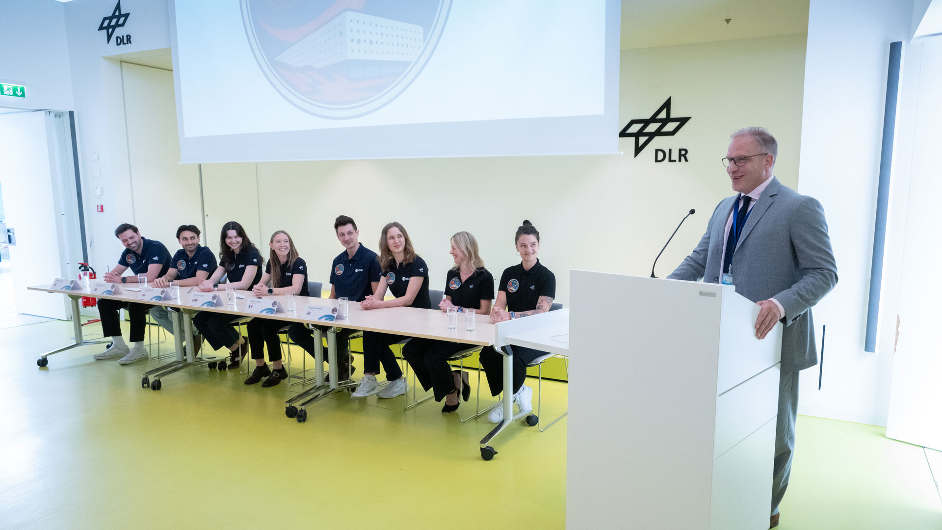 Institutsdirektor Prof. Jens Jordan steht am Rednerpult. Die SOLIS100-Crew und die beiden DLR-Projektleiterinnen sitzen gemeinsam auf der Bühne.