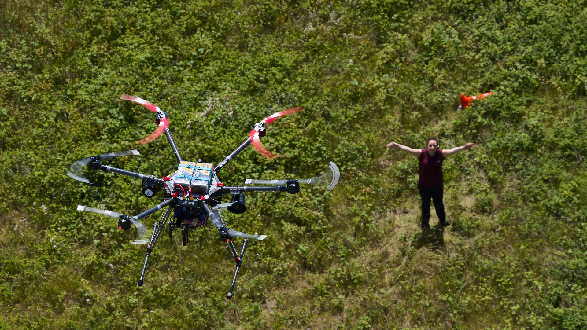 Drohne im Flug im Anflug an eine Person am Boden