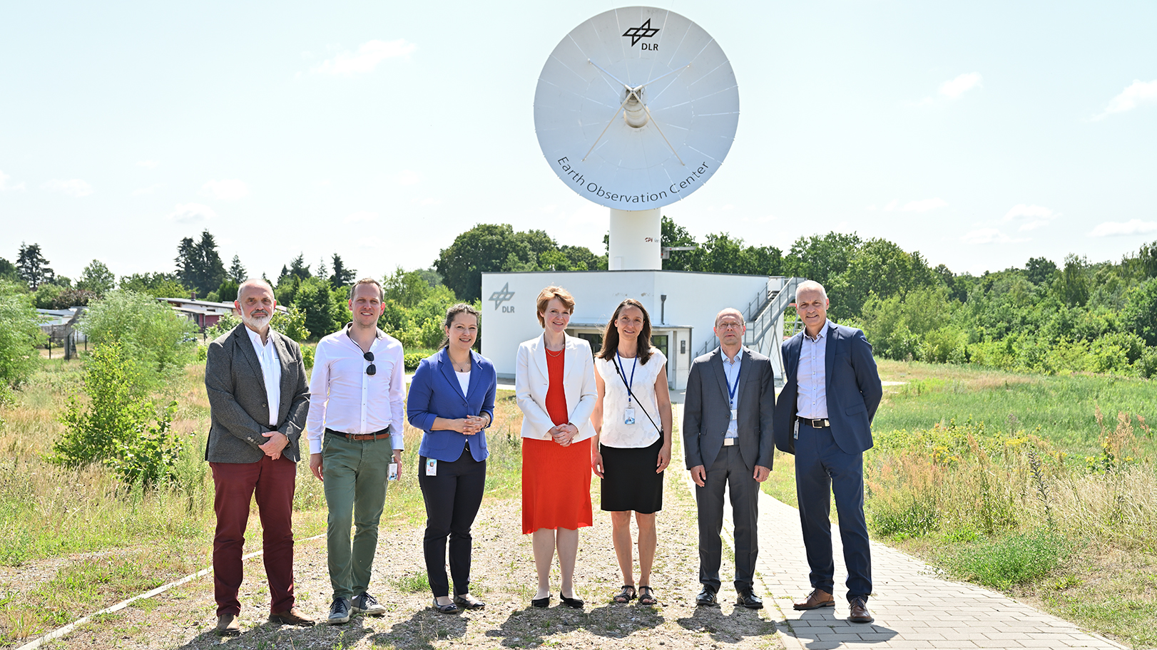 Gruppenfoto vor einer Antenne am Standort Neustrelitz