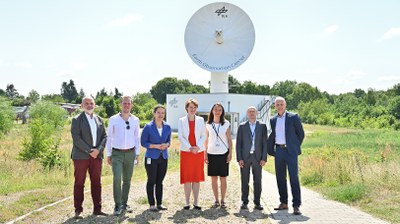 Gruppenfoto vor einer Antenne am Standort Neustrelitz