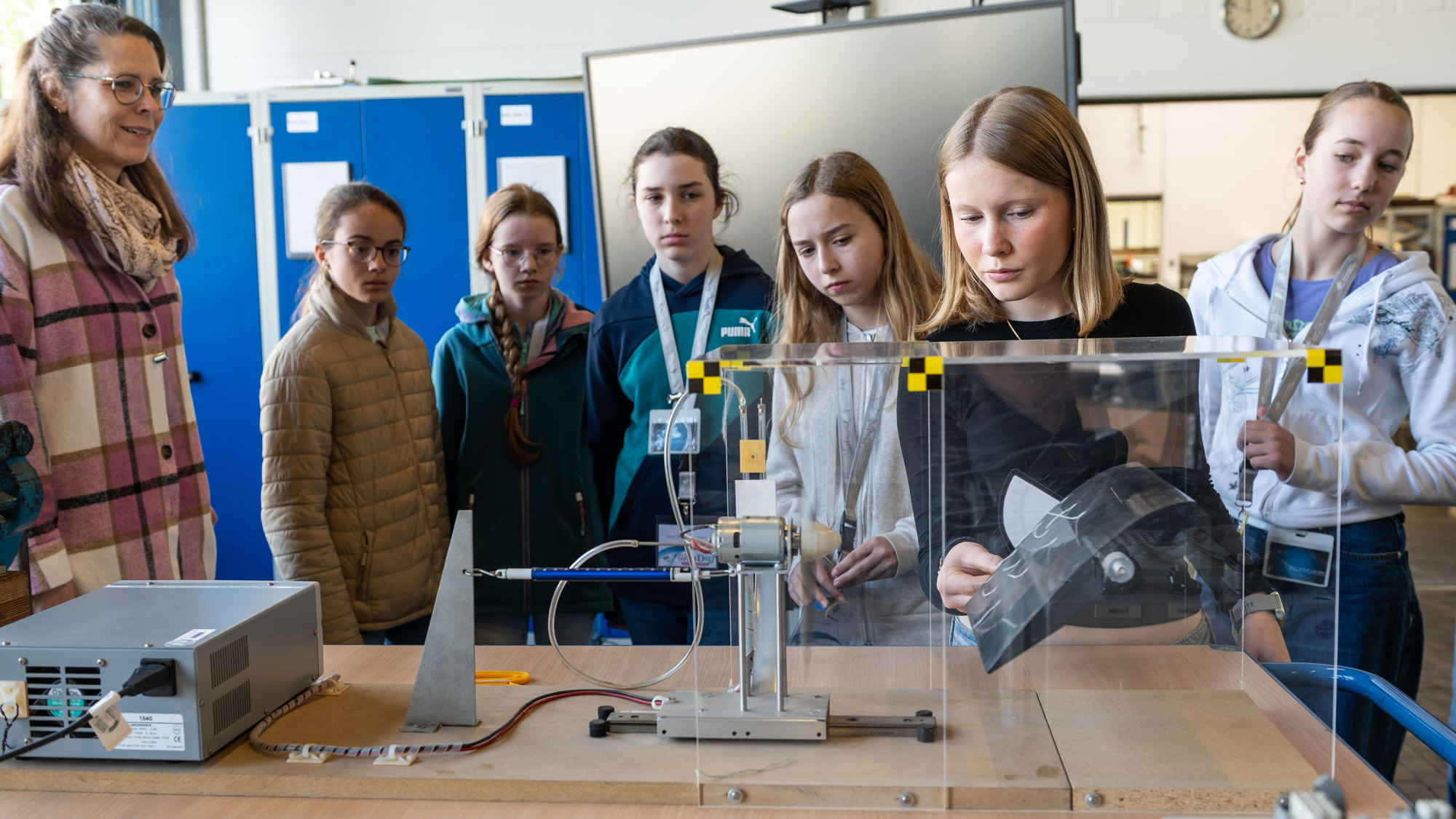 Bei einem Experiment erklärt Dr. Melanie Voges den Schülerinnen den Strömungseinfluss der Luft auf Tragflügel.
