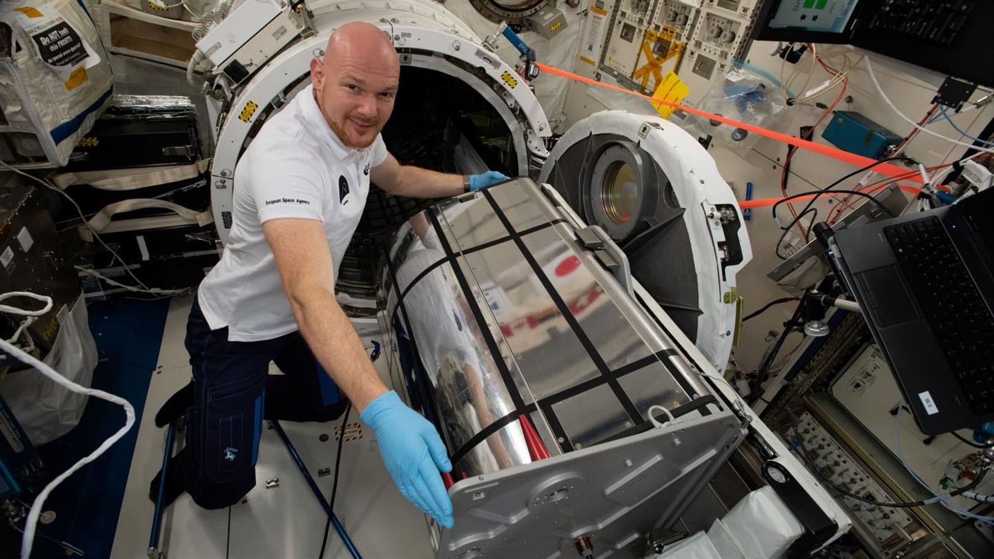 Alexander Gerst packt das Hyperspektralinstrument DESIS des Deutschen Zentrums für Luft- und Raumfahrt (DLR) aus.