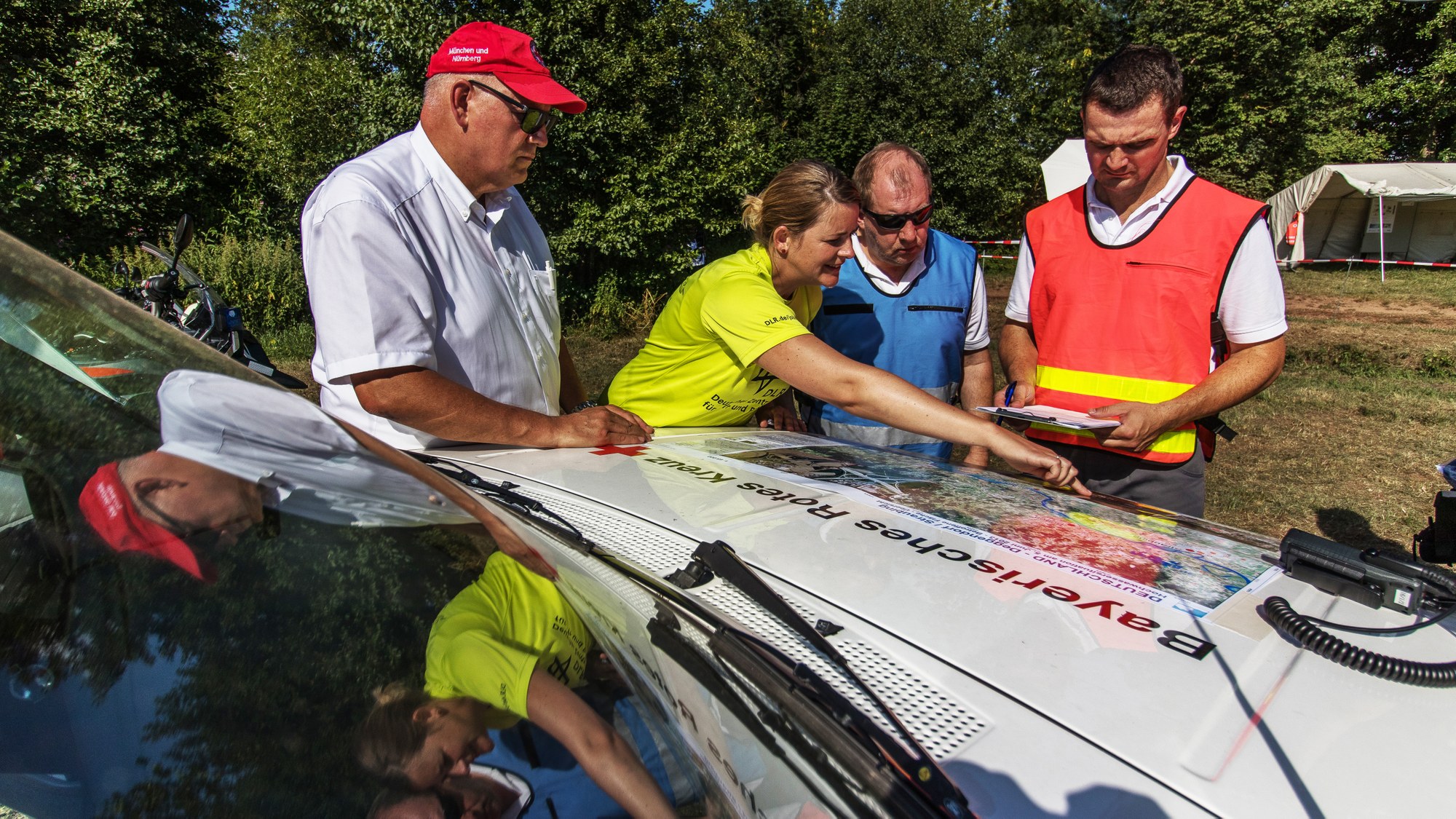 Lagebesprechung bei der Schnell-Einsatz-Gruppe (SEG) mit Kartenmaterial des DLR