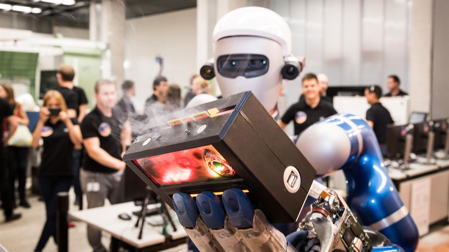 Roboter METERON SUPVIS-Justin hält brennendes Stationsmodul