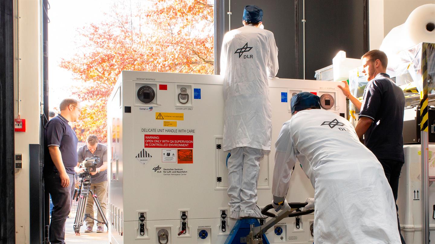 Mitarbeiter des DLR schieben die Transportkiste des Satelliten Eu:CROPIS zur Verladung für den Transport zum Flughafen.