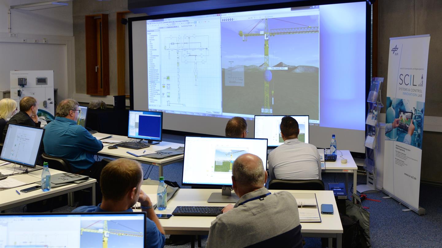 Die Teilnehmer des SCIL Workshops bauen interaktiv den Digitalen Prototypen eines Baukrans auf.