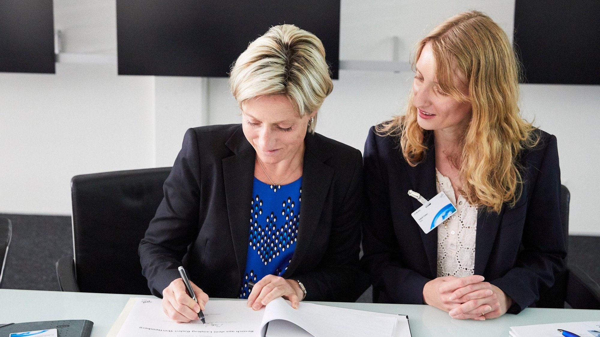 Wirtschaftsministerin Dr. Nicole Hoffmeister-Kraut und Isabell Huber, MdL tragen sich ins Gästebuch des Standort Lampoldshausen ein.