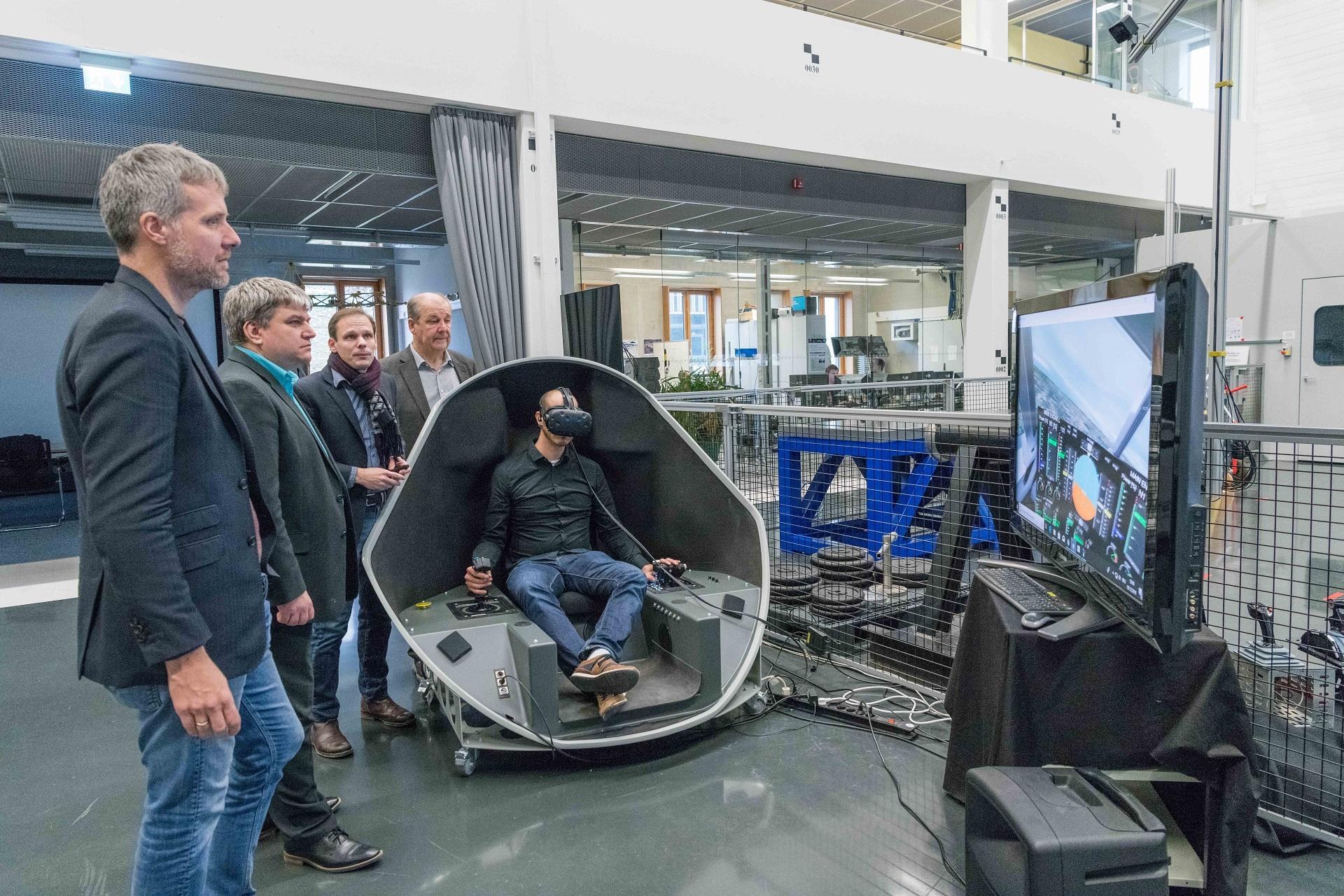 Abgeordnete betrachten Neuerungen in der Forschung des Instituts für Systemdynamik und Regelungstechnik