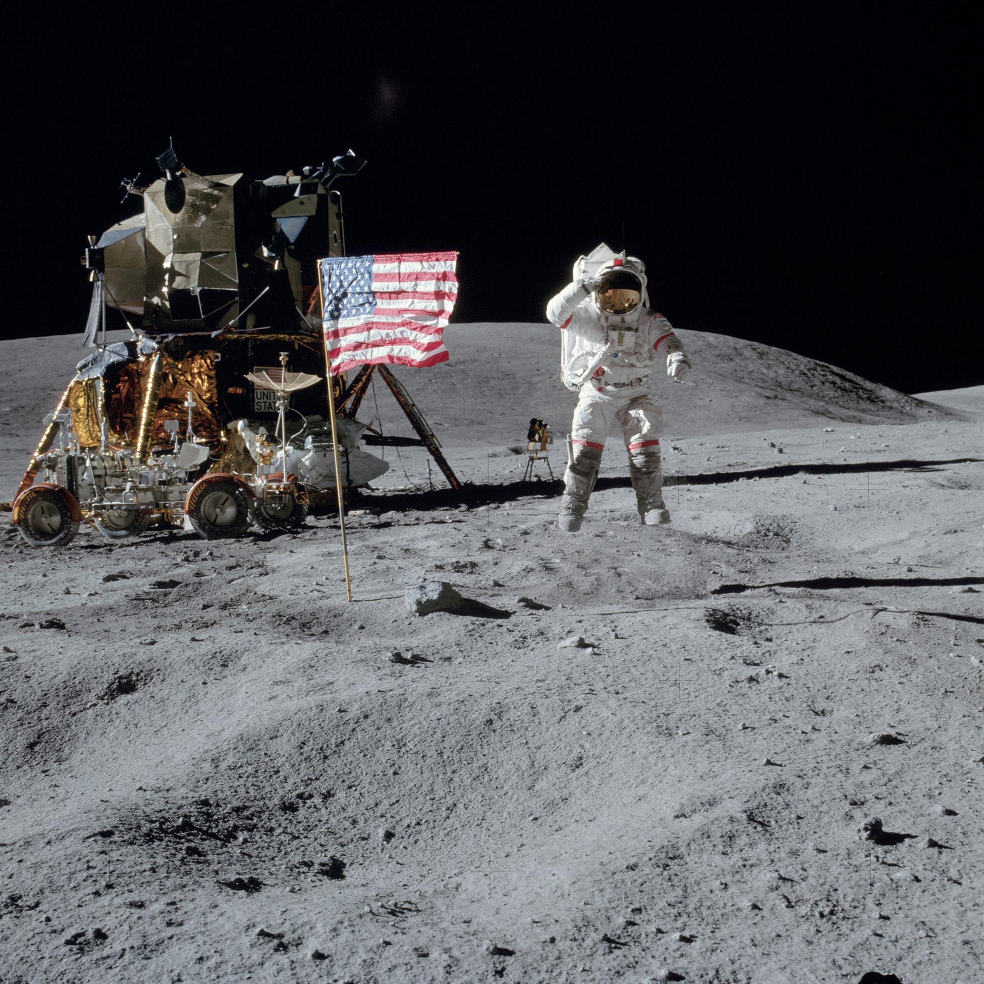 John Young springt und salutiert an der U.S.-Flagge