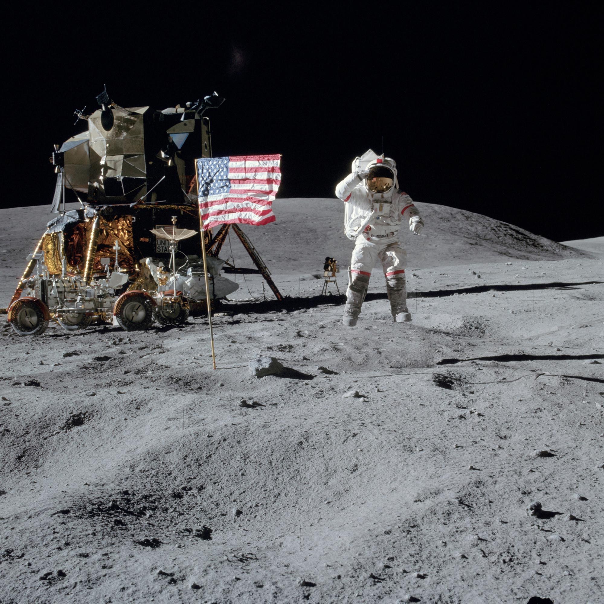 John Young springt und salutiert an der U.S.-Flagge