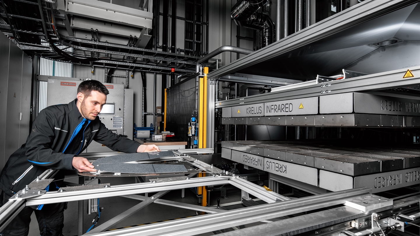 Mitarbeiter bei der manuellen Bestückung des Transfersystems