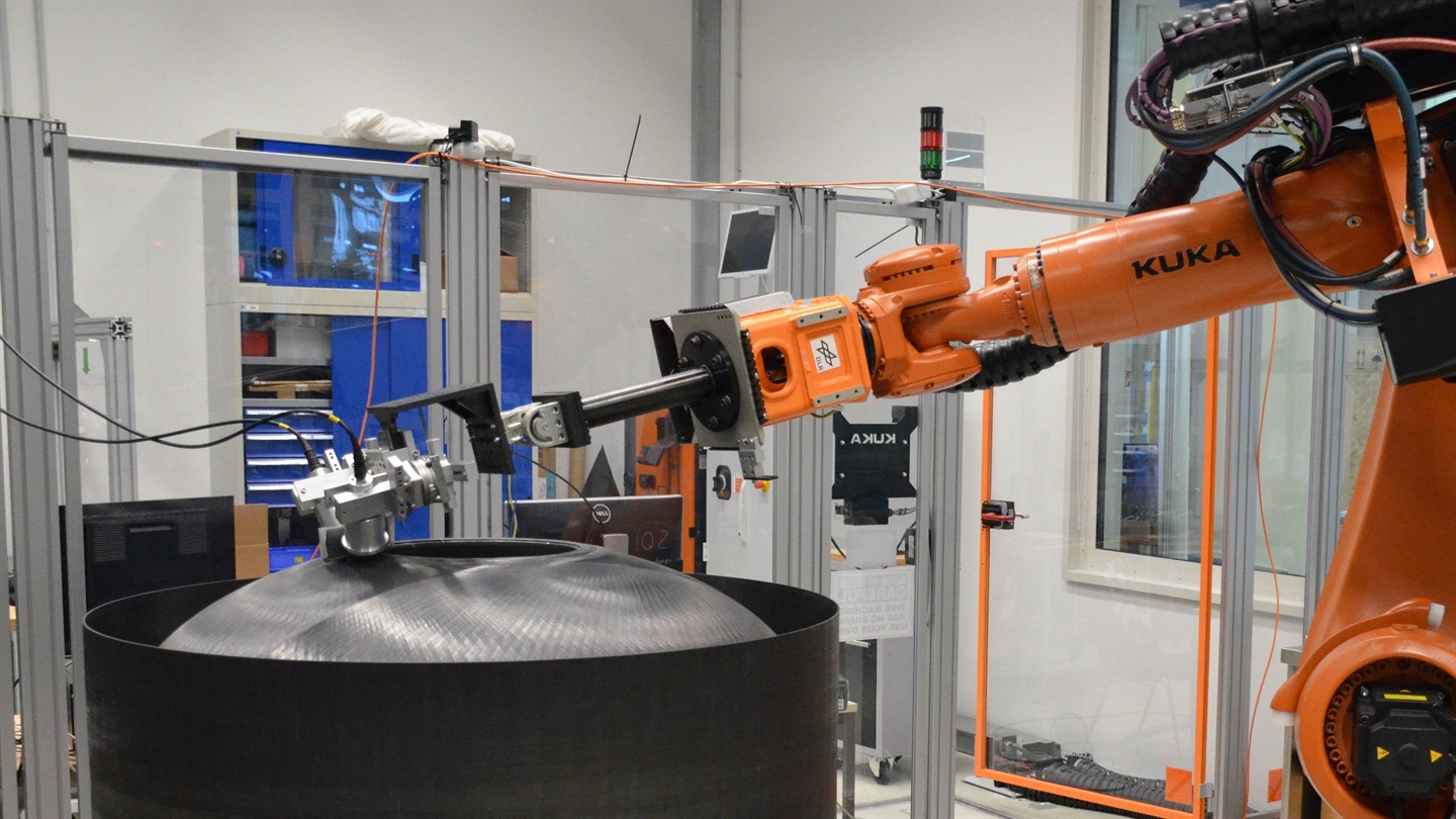 KUKA Industrieroboter der eine luftgekoppelte Ultraschallprüfung an einem Druckdom durchführt