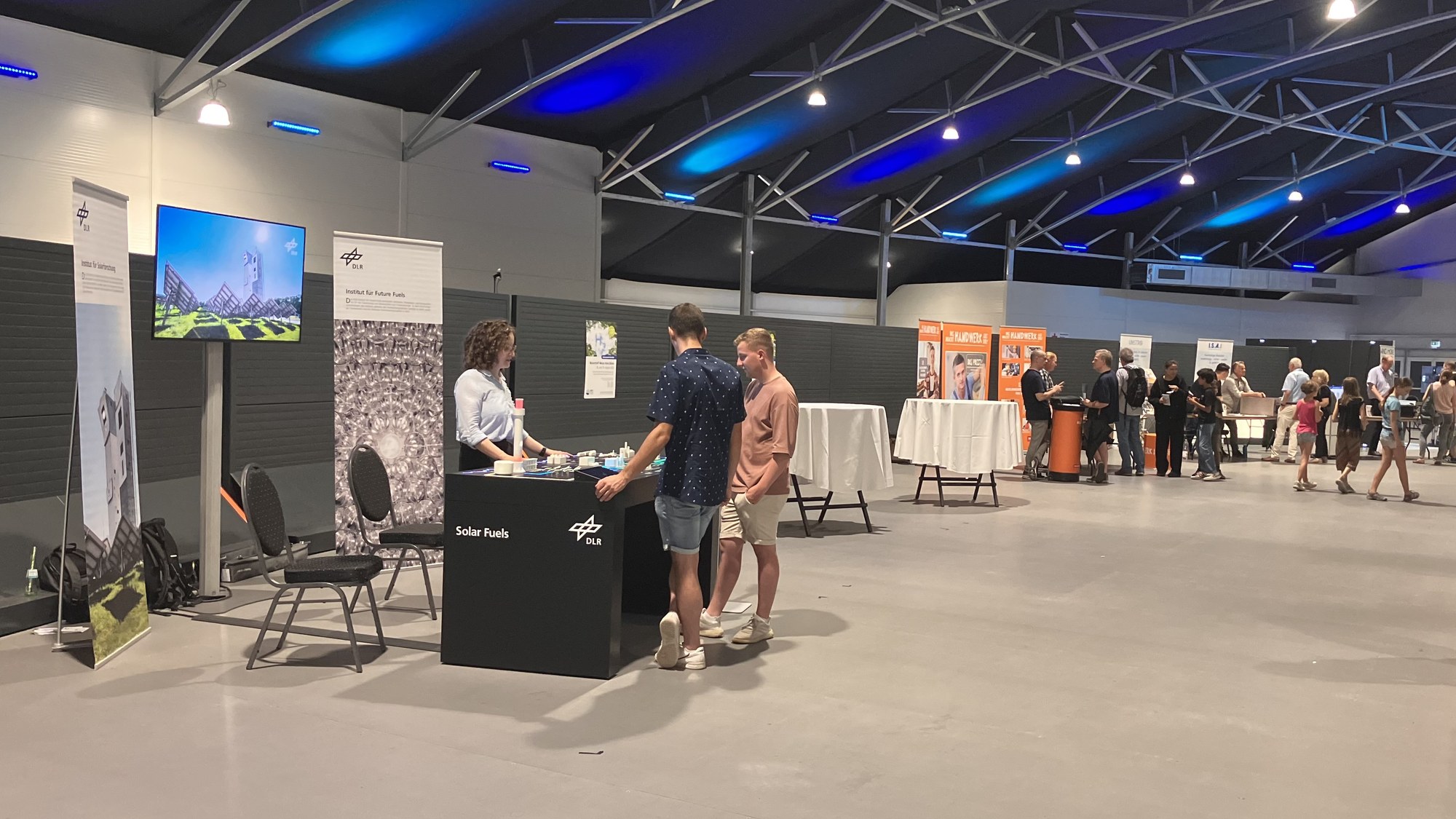 Eine Forscherin des Instituts erläutert interessierten Besuchern das Exponat Solar Fuels.