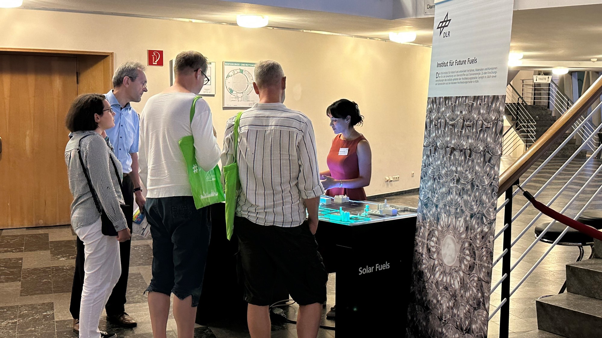 Besuchende stehen am DLR-Stand bei der Nacht der Technik 2023.
