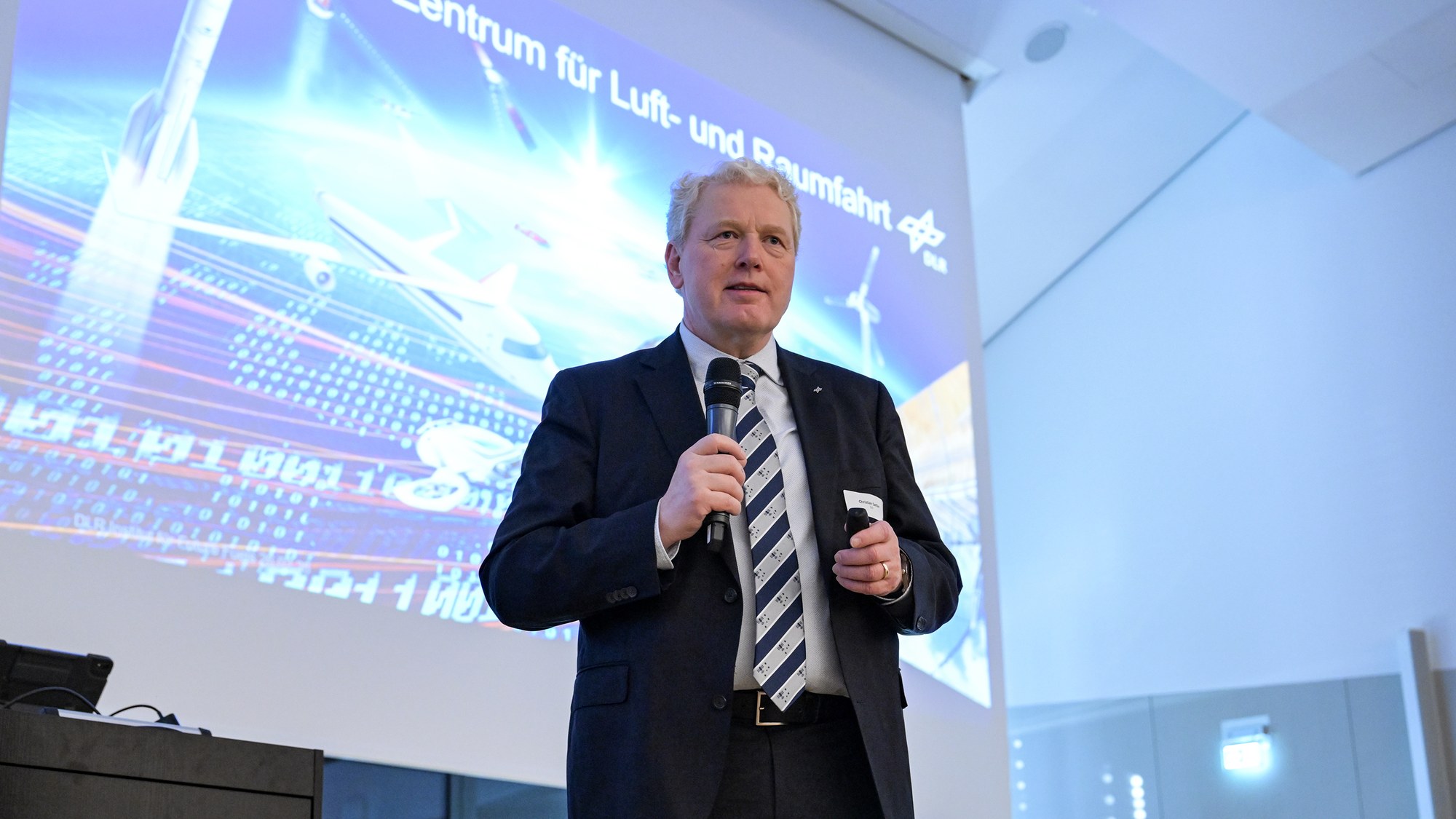 Prof. Dr. Christian Sattler spricht auf der Bühne zum Publikum.