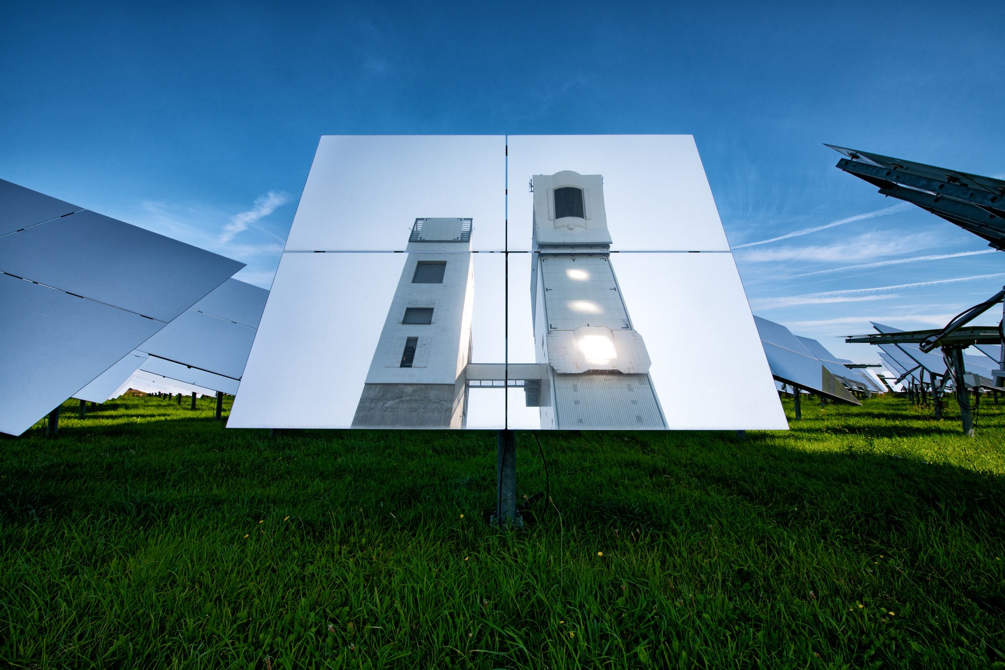 Ein Heliostat, in dem sich die beiden Solartürme Jülich spiegeln.