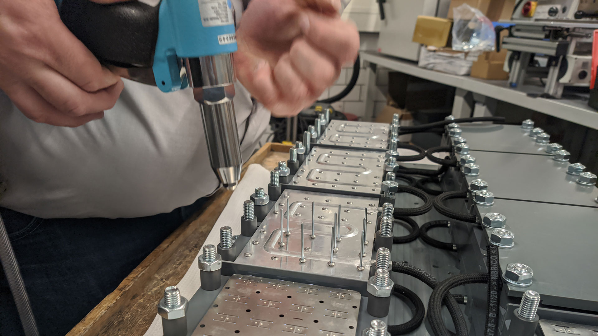 Die Kühlplatten werden auf die Stromableiter der Batterie genietet.