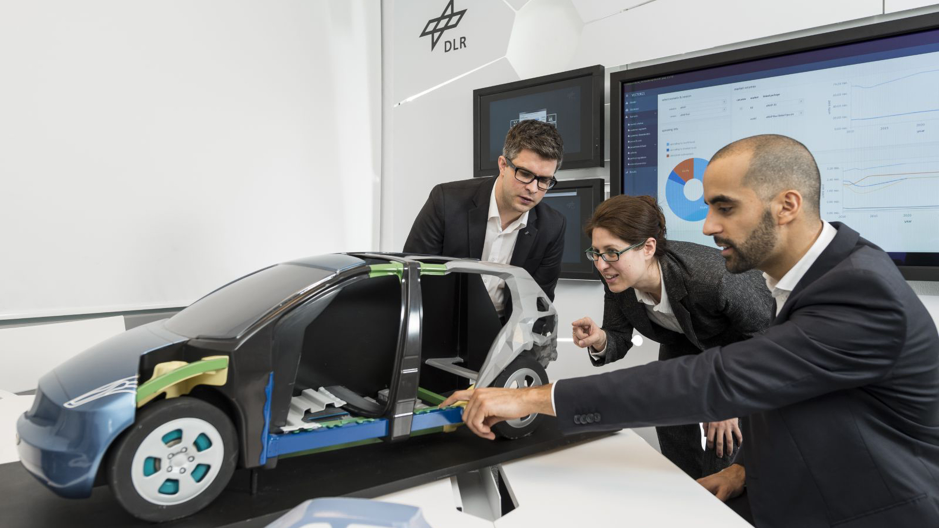 Personen vor einem Fahrzeugmodell