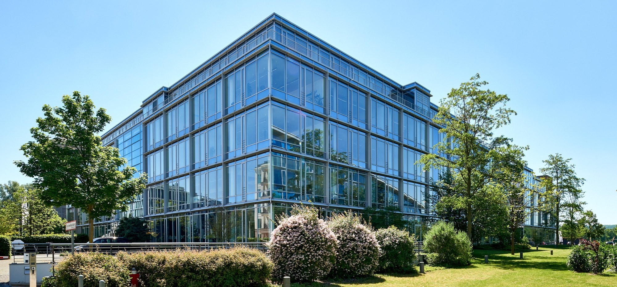 An office building belonging to the DLR Project Management Agency for Aviation Research. In front of it, a green lawn and plants.
